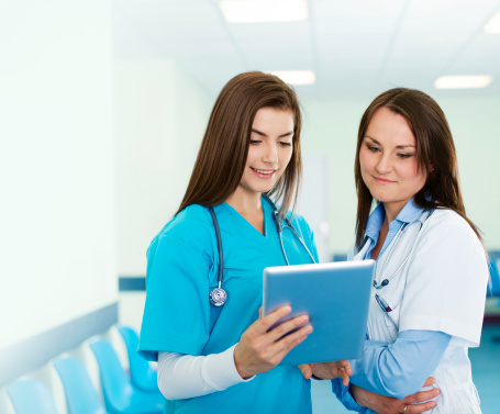Female doctors checking results on digital tablet