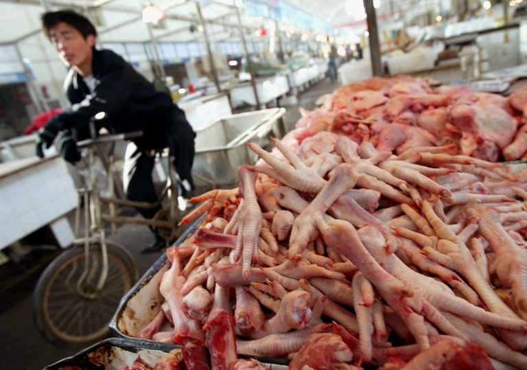   FILE - This Feb. 9, 2004 file photo shows a man cycling past chicken feet on sale in a market in Tongxian, a suburb of Beijing. The World Trade Organization (WTO) ruled in favor of the U.S. on Friday in a long-standing trade dispute over allegations China unfairly imposed anti-dumping tariffs that restricted American poultry exports. The chicken dispute is part of a larger strain in trade relations between the world's two largest economies. The U.S. appeal to the WTO dates to 2011, after China said that America had engaged in dumping and had imposed tariffs on imports of so-called 