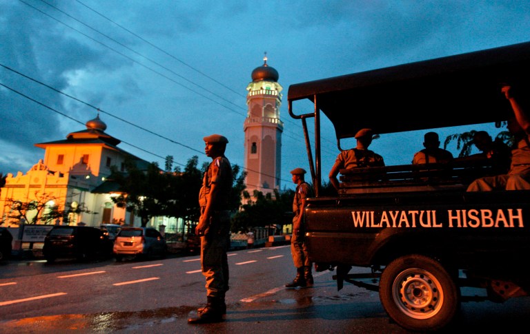 Sharia police officers stand guard at a check point set up to prevent people from celebrating New Year's eve in Banda Aceh, Aceh Province, Indonesia. (AP/Heri Juanda)