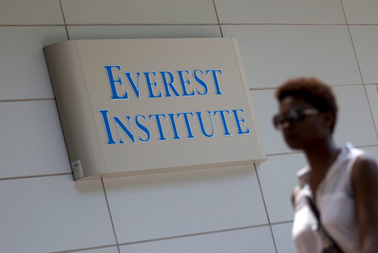 A person walks past an Everest Institute sign in a office building in Silver Spring, Md., Tuesday, July 8, 2014. The dozen campuses that for-profit education company Corinthian Colleges Inc. is closing operate under the Everest name and are scattered in 11 different states, the company announced. (AP Photo/Jose Luis Magana)