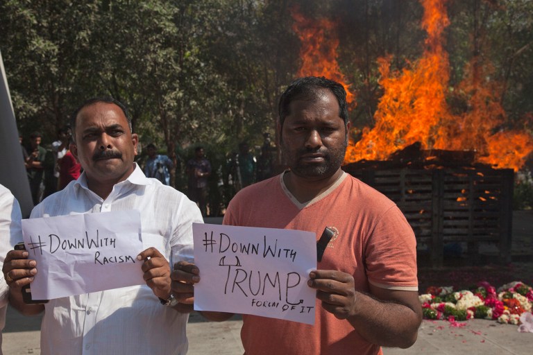 Indians hold placards in front of the cremation pyre of Srinivas Kuchibhotla, a 32-year-old engineer who was killed in an apparently racially motivated shooting in a crowded Kansas bar, at a crematorium in Hyderabad, India, Tuesday, Feb.28, 2017. According to witnesses, the gunman yelled 
