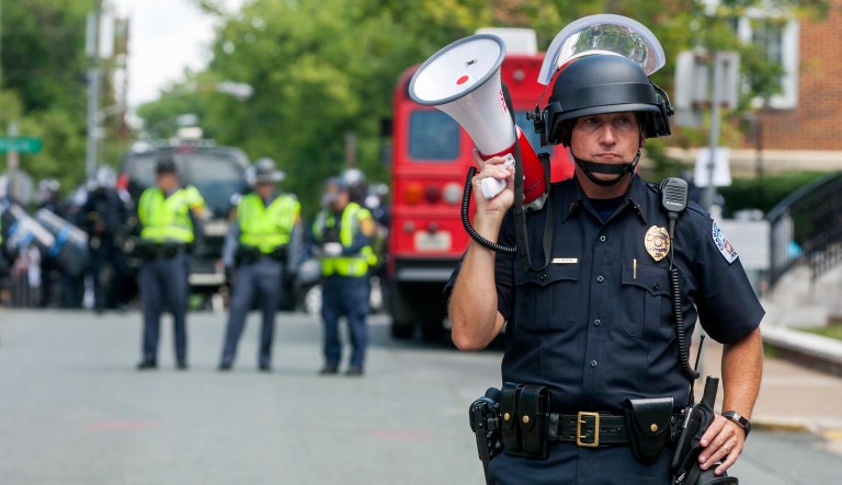 A police officer stands in the middle of the street after declaring the protest an unlawful assembly during a white nationalist rally, on Saturday Aug. 12, 2017, in Charlottesville, Va. (Shaban Athuman/Richmond Times-Dispatch via AP)