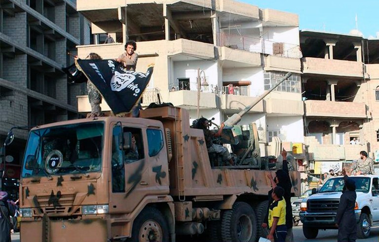 This undated image posted by the Raqqa Media Center, a Syrian opposition group, on Monday, June 30, 2014, shows fighters from the al-Qaida linked Islamic State during a parade in Raqqa, Syria. (AP Photo/Raqqa Media Center)