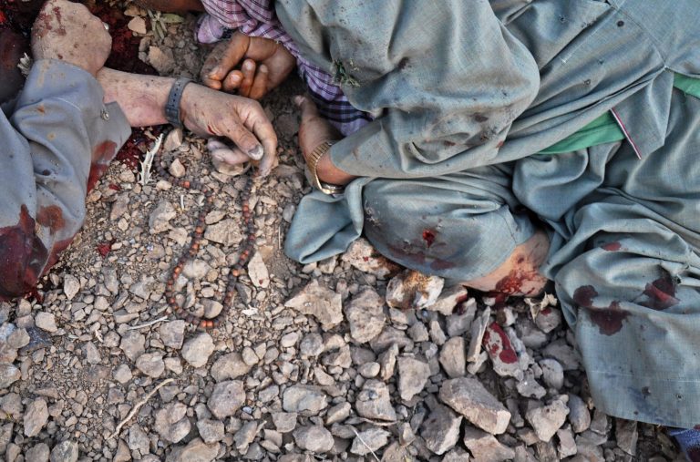 The dead bodies of Shiite civilians, one with fallen prayer beads nearby, are seen on the ground after Taliban insurgents stopped their bus on the road in the western Ghor province of Afghanistan, Friday, July 25, 2014. The militants halted minibuses, identified more than a dozen Shiite passengers and shot them dead by the side of the road overnight Friday, an official said. (AP Photo)