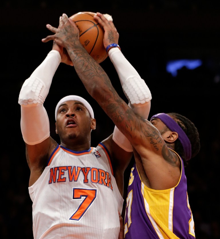   Los Angeles Lakers center Jordan Hill,right, gets his hand on the ball as New York Knicks forward Carmelo Anthony, left, goes up for a layup in the first half of their NBA basketball game at Madison Square Garden in New York, Thursday, Dec. 13, 2012. (AP Photo/Kathy Willens)  