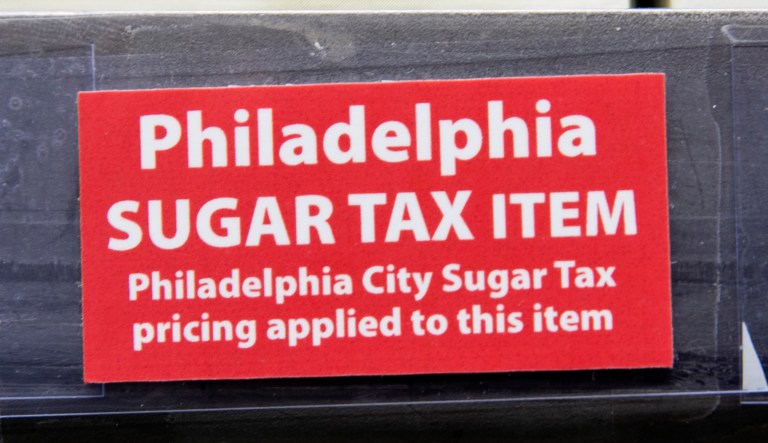 This March 16, 2017 photo shows a sticker alerting customers of the sugar tax posted by sweetened beverages at the IGA supermarket in the Port Richmond neighborhood of Philadelphia. (AP Photo/Matt Rourke)