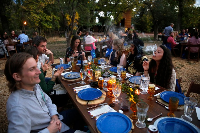 Diners smoke marijuana as they eat dishes prepared by chefs during an evening of pairings of fine food and craft marijuana strains served at an outdoor venue in Colorado. Denver has approved a first-in-the-nation law allowing people to use marijuana in bars and restaurants. (AP Photo/Brennan Linsley, File)