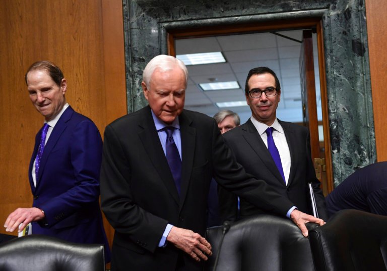 Treasury Secretary Steven Mnuchin, right, arrives to testify before the Senate Finance Committee on Capitol Hill in Washington, Wednesday, Feb. 14, 2018, on President Donald Trump's fiscal year 2019 budget proposal along with committee ranking member Sen. Ron Wyden, D-Ore., left, and committee chairman Sen. Orrin Hatch, R-Utah, center. (AP Photo/Susan Walsh)