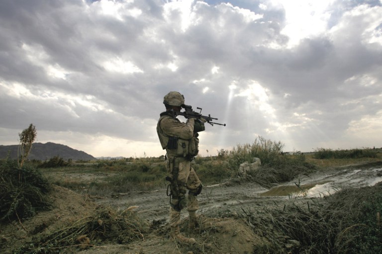A soldier looks through the scope of his rifle as he guards a engineer road construction project near the Mas'um Ghar base in the Kandahar Province of Afghanistan in this Wednesday Nov. 22, 2006 photo. (AP Photo/David Guttenfelder)