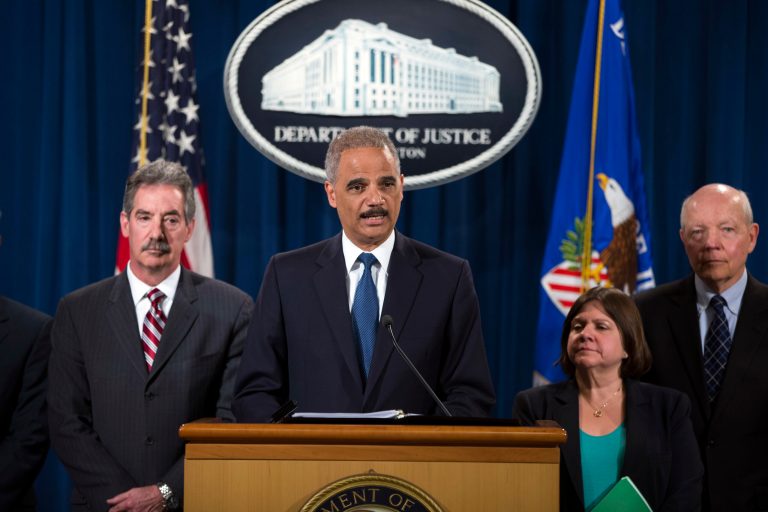 Attorney General Eric Holder, center, speaks during a news conference at the Justice Department, on Monday, May 19, 2014, in Washington. The Justice Department on Monday charged Credit Suisse AG with helping wealthy Americans avoid paying taxes through offshore accounts, and a person familiar with the matter said the European bank has agreed to pay about $2.6 billion in penalties. From left, Deputy Attorney General James Cole, Holder, Assistant Attorney General for the Tax Division Kathryn Keneally, and IRS Commissioner John Koskinen (AP Photo/ Evan Vucci)