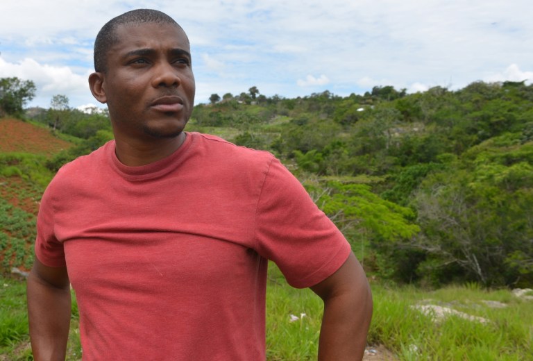 In this May 20, 2014 photo, Howard Bailey pauses as he speaks to a journalist as he works on his neighbor's farm in Bohemia, Jamaica. The 42-year-old father of two was deported in May 2012 from the U.S. to his Caribbean homeland because he was convicted of a marijuana-related felony drug charge in 1997, despite the four years he served in the Navy, including a few months on a supply ship during the first Gulf War. (AP Photo/David McFadden)