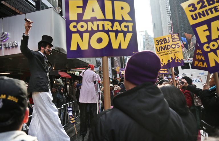   Stilt actors perform a skit during a protest of theater workers from union SEIU Local 32BJ, outside the Broadway League's office, before a vote authorizing a strike on Wednesday, Dec. 12, 2012, in New York. The union representing hundreds of Broadway theater cleaners, porters, elevator operators and bathroom attendants voted Wednesday to authorize its leaders to call a strike if a new contract isn't approved by the end of the month, (AP Photo/Bebeto Matthews)  