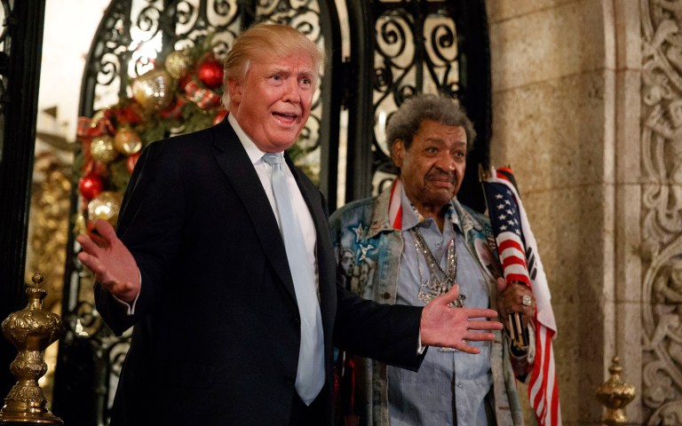 Former boxing promoter Don King holds a bundle of flags as he stands next to President-elect Trump during a brief press conference at Mar-a-Lago in Palm Beach, Fla. (AP Photo/Evan Vucci)