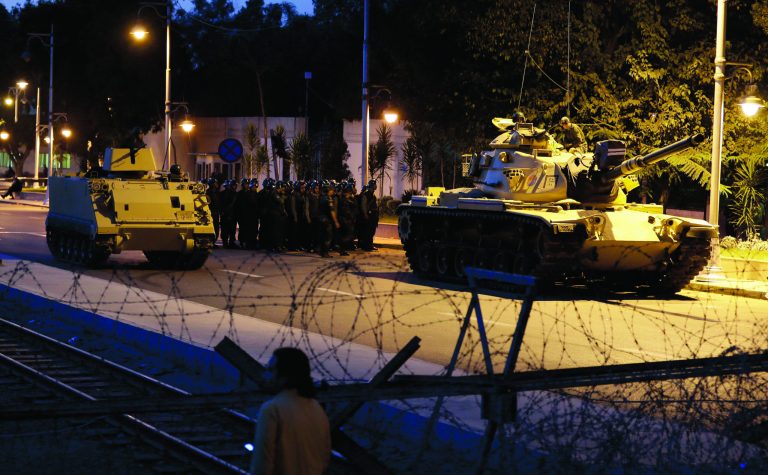 An Egyptian Army tank deploys outside the presidential palace, in Cairo, Egypt, Thursday, Dec. 6, 2012. The Egyptian army sealed off the presidential palace with barbed wire and armored vehicles Thursday as protesters defied a deadline to vacate the area, pressing forward with demands that Islamist leader Mohammed Morsi rescind decrees giving himself near-absolute power and withdraw a disputed draft constitution.(AP Photo/Hassan Ammar)