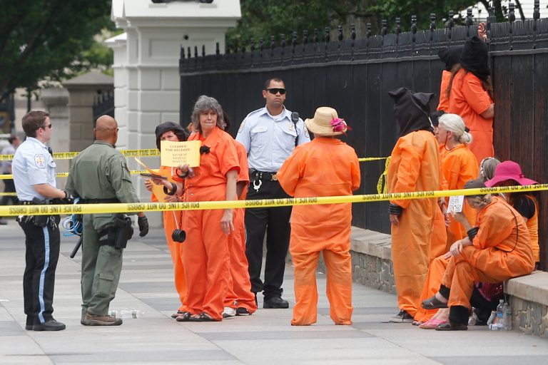Police arrest demonstrators wearing orange jumpsuits while protesting the Guantanamo Bay military detention facility in front of the White House in Washington on June 26. (AP Photo/Charles Dharapak)