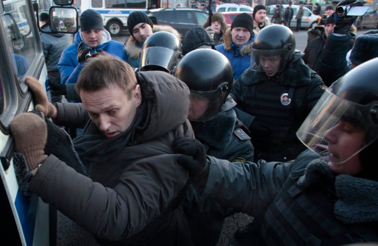   FILE - In this Saturday, Dec. 15, 2012 file photo police officers detain opposition leader Alexei Navalny during an unauthorized rally in Lubyanka Square in Moscow. Navalny, who helped organized the largest anti-Kremlin rallies in Russia's post-Soviet history, was charged with fraud and money-laundering Thursday. (AP Photo/Pavel Golovkin, File)  