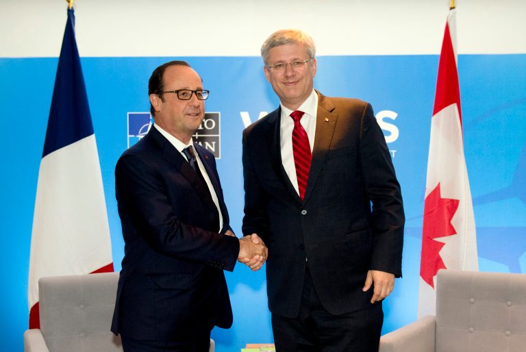 France's President Francois Hollande, left, shakes hands with Canada's Prime Minister Stephen Harper at a bilateral meeting on the second day of the NATO 2014 Summit at the Celtic Manor Resort in Newport, South Wales, on  Friday, Sept. 5, 2014. NATO leaders are expected to announce a raft of fresh sanctions against Russia on Friday over its actions in Ukraine, although hopes remain that a ceasefire can be forged at peace talks in Minsk on the same day.  (AP Photo/Alain Jocard, Pool)