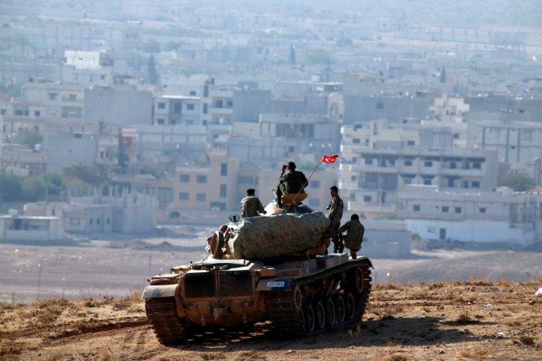 Turkish soldiers on a tank hold their position on a hilltop on the outskirts of Suruc, at the Turkey-Syria border, overlooking Kobani, Syria, during fighting between Syrian Kurds and the militants of Islamic State group, Oct. 9, 2014. (AP Photo/Lefteris Pitarakis)