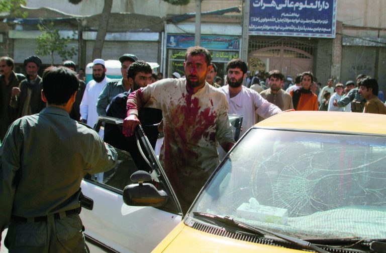 A wounded Afghan man sits in a car at the scene of an explosion in Herat, west of Kabul, Afghanistan, Wednesday, Aug. 15, 2012. More than a dozen people, including four women and a policeman, were injured when explosives set up on a bicycle exploded at a market in the city of Herat while people were shopping for an upcoming Muslim holiday, said Noor Khan Nekzad, a spokesman for the provincial police. (AP Photo/Hoshang Hashimi)