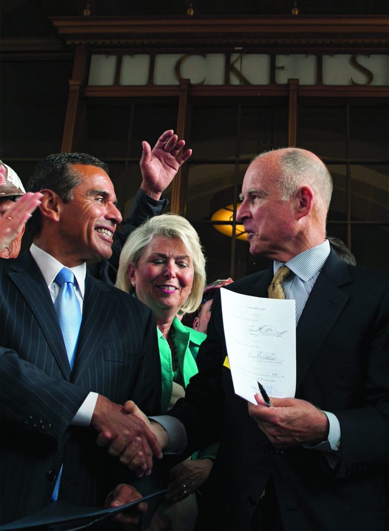 California Gov. Jerry Brown, right, holds signed legislation authorizing initial construction of California's $68 billion high-speed rail line with Los Angeles Mayor Antonio Villaraigosa at Los Angeles' Union Station Wednesday, July 18, 2012. (AP Photo/Damian Dovarganes)