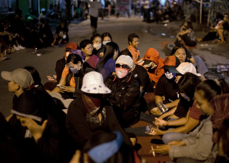 Sex workers of Dolly red-light district sit on the road in a protest  against the closing of the prostitution complex in Surabaya, East java, Indonesia, Wednesday, June 18, 2014. The government has shut down a red-light district in Indonesia's second largest town amid protests by pimps and sex workers as well as dependents.  (AP Photo/Dita Alangkara)
