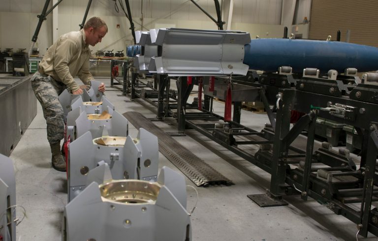 An airman prepares the tails of a Paveway II guided bomb for assembly. Paveways helped Raytheon increase net sales in the second quarter. (Air Force Photo)