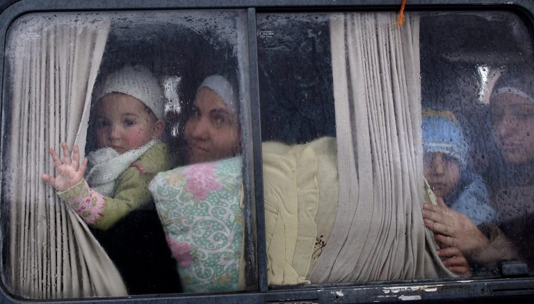   Syrian refugees, who fled their home in Idlib due to a government airstrike, look out of a vehicle's window just after crossing the border from Syria to Turkey, in Cilvegozu, Turkey, Thursday, Dec. 20, 2012. (AP Photo/Muhammed Muheisen)  