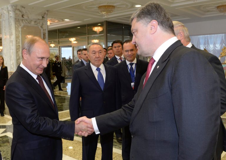 Russian President Vladimir Putin, left, shakes hands with Ukrainian President Petro Poroshenko, right, as Kazakh President Nursultan Nazarbayev, center, looks at them, prior to their talks after after posing for a photo in Minsk, Belarus, Tuesday, Aug. 26, 2014. Leaders of Russia, Belarus, two other former Soviet republics as well as top EU officials are meeting in Minsk, Belarus, for a highly anticipated summit to discuss the crisis in Ukraine which has left more than 2,000 dead and displaced over 300,000 people. (AP Photo/Kazakh Presidential Press Service, Sergei Bondarenko, Pool)
