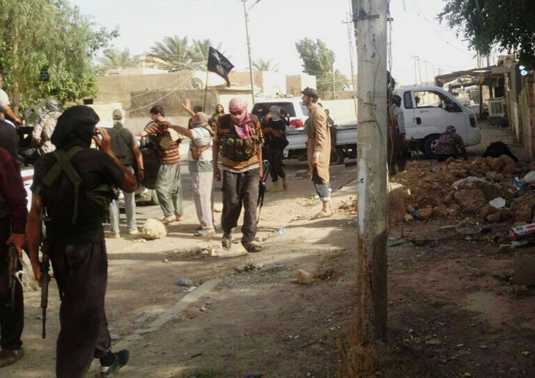 Militias of the al-Qaida breakaway group Islamic State of Iraq and the Levant (ISIL) deploy in an area in Tikrit, 80 miles (130 kilometers) north of Baghdad, Iraq, Wednesday, June 11, 2014. Al-Qaida-inspired militants seized effective control Wednesday of Saddam Hussein's hometown of Tikrit, expanding their offensive closer to the Iraqi capital as soldiers and security forces abandoned their posts following clashes with the insurgents. (AP Photo)