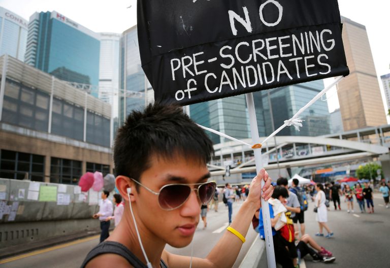 A student pro-democracy activist holds up a placard at the protest site, Thursday, Oct. 2, 2014 in Hong Kong. China warned of 