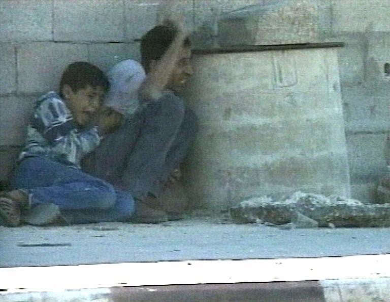 ** FILE ** In this Sept. 30, 2000 file image from television, Jamal al-sutra signals his position while protecting his 12-year-old son Mohammed al-Dura, as they shelter behind a barrel from crossfire near Netzarim Jewish settlement in the southern Gaza Strip. More than a dozen years later, the death of a Palestinian boy allegedly shot by Israeli troops in Gaza continues to stir emotions on both sides of the conflict. A new Israeli report that tries to debunk the Palestinian narrative of the incident shows no signs of ending the saga, which for Palestinians has became a symbol of Israeli oppression and for Israel is a nasty smear campaign aimed at demonizing it. (AP Photo/France 2, Fille) ** NO SALES TV OUT ***FRANCE OUT ***