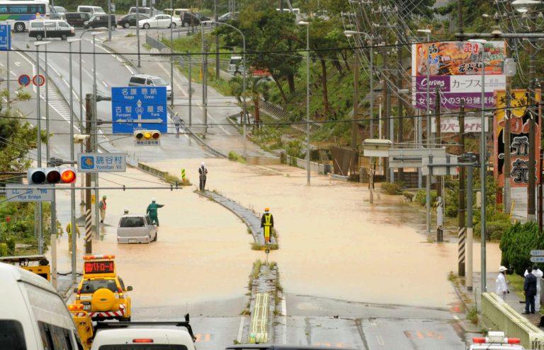 A road is submerged by an overflowed river following a typhoon in Yomitan, Okinawa, Wednesday, July 9, 2014. A powerful storm slammed through the southwestern Japanese island of Okinawa, leaving at least 28 people injured and 63,000 homes without power before swerving toward the bigger island of Kyushu on Wednesday. (AP Photo/Ryukyu Shimpo via Kyodo News) JAPAN OUT, NO SALES, NO ARCHIVE, MANDATORY CREDIT