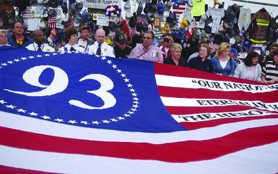 A flag is unfolded at a memorial site on the 5th anniversary of the Sept. 11, 2001, attacks.