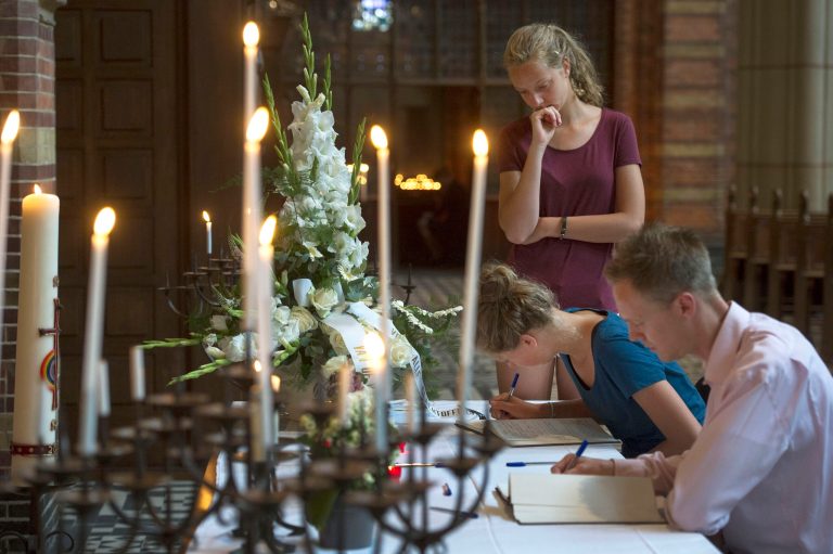 People sign a condolence register at St. Vitus church in Hilversum, Netherlands, Sunday, July 20, 2014. An attack on a Malaysian jetliner shot down over Ukraine on Thursday killed 298 people from nearly a dozen nations, more than half being Dutch. Worshippers at church services across the Netherlands prayed Sunday for the victims of the Ukraine air disaster and their next of kin, as anger built over the separatist rebels' hindering of the investigation into the downing of Malaysia Airlines Flight 17. (AP Photo/Patrick Post)