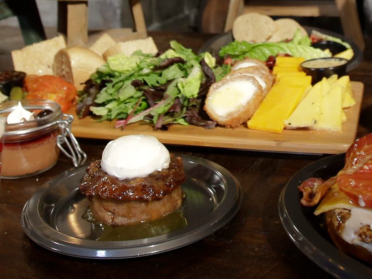 Sticky Toffee pudding, front center, is displayed along with the Ploughman's Platter, back, available at the Leaky Cauldron restaurant during a preview of Diagon Alley at the Wizarding World of Harry Potter at Universal Orlando, Thursday, June 19, 2014, in Orlando, Fla. (AP Photo/John Raoux)