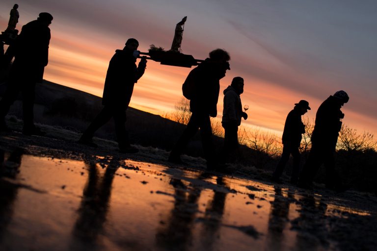 Winemakers carry antique wooden statues of their patron saint through the vineyards, during an annual rite known as the Saint Vincent Tournante, in Saint-Aubin, central France, Saturday, Jan. 25, 2014. Early in the morning, oenophiles from across France have gathered in this tiny Burgundian village to celebrate a medieval tradition in honor of Saint Vincent, the patron saint of winemakers. Upwards of 40,000 people are expected for the two-day festival, which takes place in a different Burgundian village each year. Following the vineyard procession and a mass, local winemakers open their cellar doors for tastings of their chardonnays and pinot noirs. Organizers say 15,000 bottles of wine will be opened during the weekend. (AP Photo/Laurent Cipriani)