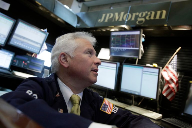 FILE - In this May, 12, 2012 file photo, Peter Castelli, a vice president with JP Morgan, works in his firm's booth on the floor of the New York Stock Exchange. JPMorgan said Friday, Oct. 25, 2013, that it has agreed to pay $5.1 billion to resolve claims that it misled Fannie Mae and Freddie Mac about risky mortgage securities it sold them before the housing market collapsed. (AP Photo/Richard Drew, File)