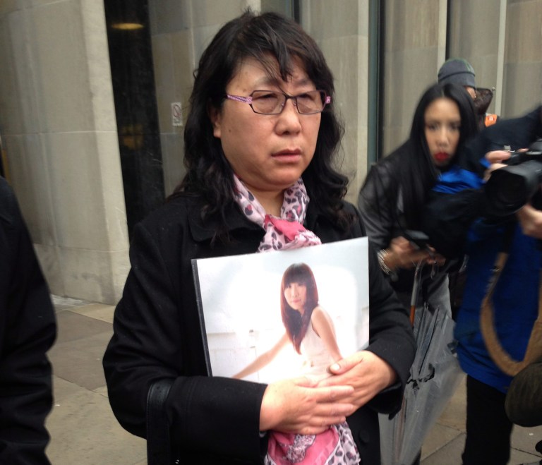 Ya Ru Zheng holds a photo of her daughter Qian Liu outside a courthouse in Toronto, on Monday, April 7, 2014. A jury has found 32-year-old Brian Dickson guilty of first-degree murder in the death of York University student Liu, from China. (AP Photo/The Canadian Press, Allison Jones)