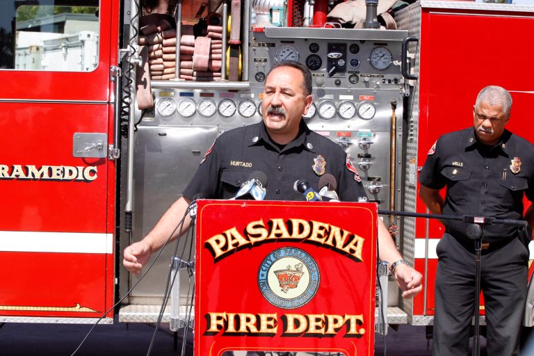 Art Hurtado, Pasadena Fire captain and paramedic takes questions during a news conference in Pasadena, Calif., Thursday, April 11, 2013. At right, Calvin Wells Pasadena Fire Chief. Hurtado helped save the life of a man at Home Depot after the victim apparently tried to cut his arms off using handsaws found at the home improvement store in West Covina, Calif. With help from police and store employees, Hurtado who was off-duty collected rope and rags from store shelves and put makeshift tourniquets on both arms, most likely saving the man's life, police said. (AP Photo/Damian Dovarganes)