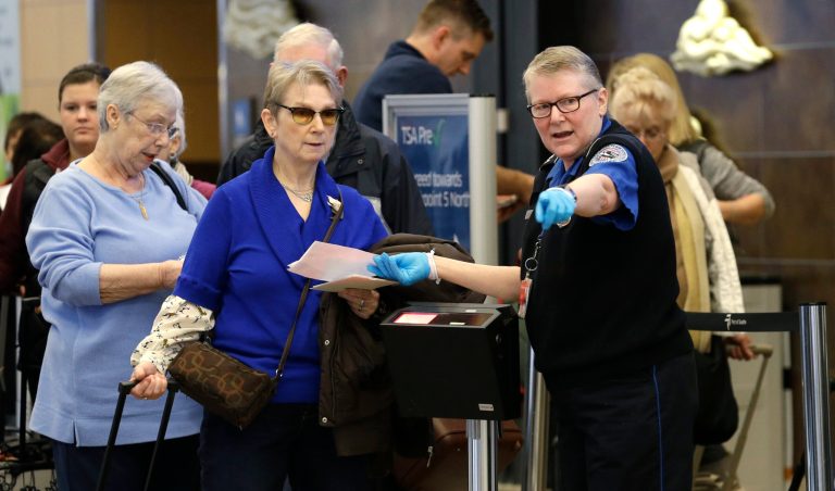 A TSA officer directs travelers at Seattle-Tacoma International Airport in Seattle on Nov. 26. (AP Photo/Elaine Thompson)