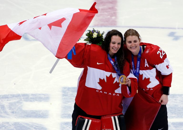 Goalkeeper Shannon Szabados of Canada (1) and Hayley Wickenheiser of Canada (22) celebrate after the medal ceremony in the women's ice hockey tournament at the 2014 Winter Olympics, Friday, Feb. 21, 2014, in Sochi, Russia. Canada won gold after defeated Team USA 3-2 in overtime. (AP Photo/Petr David Josek)