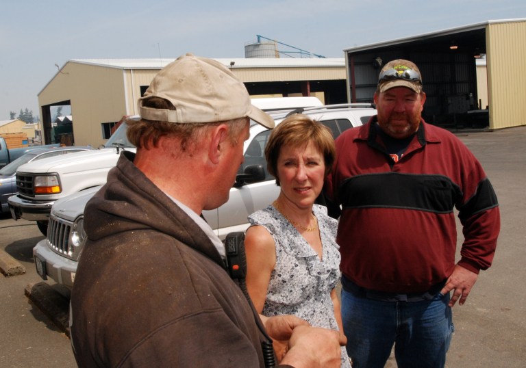 In this April 25, 2013 photo, Rough & Ready Lumber Co. co-owner Jennifer Phillippi, center, talks to workers Ron Hults, right, and Larry Matson, left, at the sawmill in O'Brien, Ore. The mill is closing after Phillippi's family has owned it for 70 years.Twenty years after environmental protections forced steep cutbacks in national forest logging, timber country is still struggling to find new jobs and sources of government revenue. (AP Photo/Jeff Barnard)