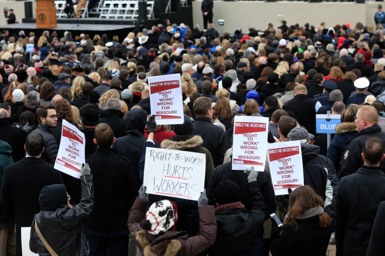 Right-to-work demonstrators hold signs in Jefferson City, Missouri. The state could become the 28th to prohibit workers from being forced to support a union as a condition of employment. (AP Photo/Orlin Wagner)