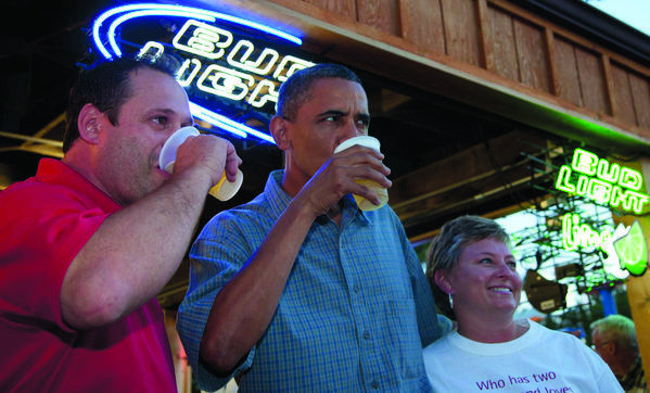 Barack Obama has a beer with Mike Cunningham, left, and another worker at the beer stand during a visit to the Iowa State Fair, Monday, Aug. 13, 2012, in Des Moines, Iowa. (AP Photo/Carolyn Kaster)