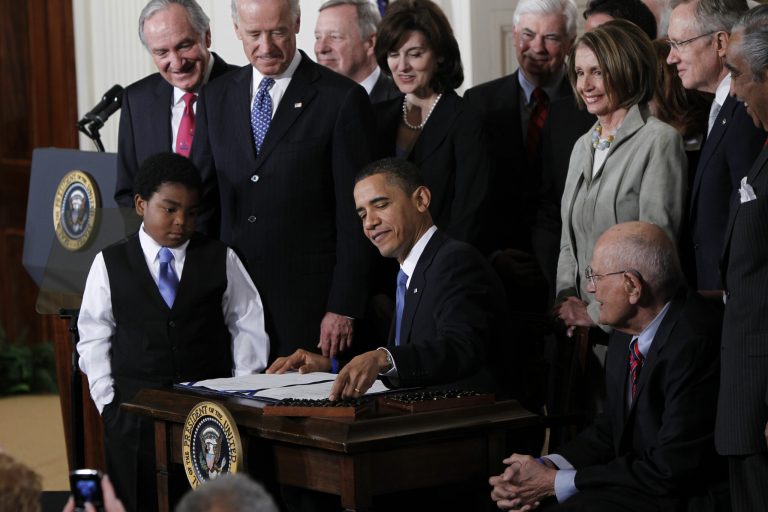 President Obama signs the Affordable Care Act into law. (AP)