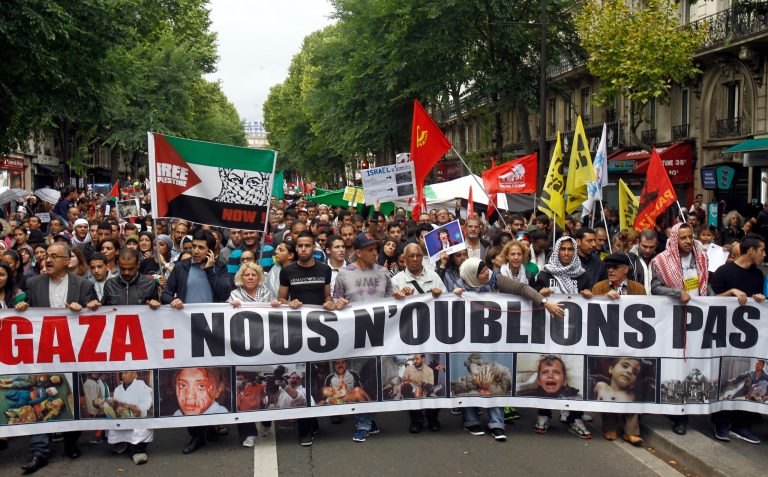 Thousands of pro-Palestinian demonstrators holding banners and chanting anti Israeli slogans walk in Paris, Sunday July 13, 2014, to protest against the Israeli army's bombings in the Gaza strip. Banner reads: 