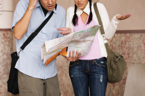 Confused couple holding map