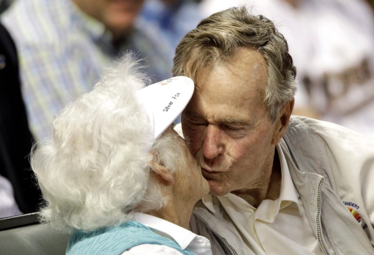 Former U.S. President George H.W. Bush, right, kisses his wife, Barbara, after both were shown on the stadium kiss cam video board during the sixth inning of a baseball game against the Arizona Diamondbacks, Wednesday, May 5, 2010, in Houston. (AP Photo/David J. Phillip)