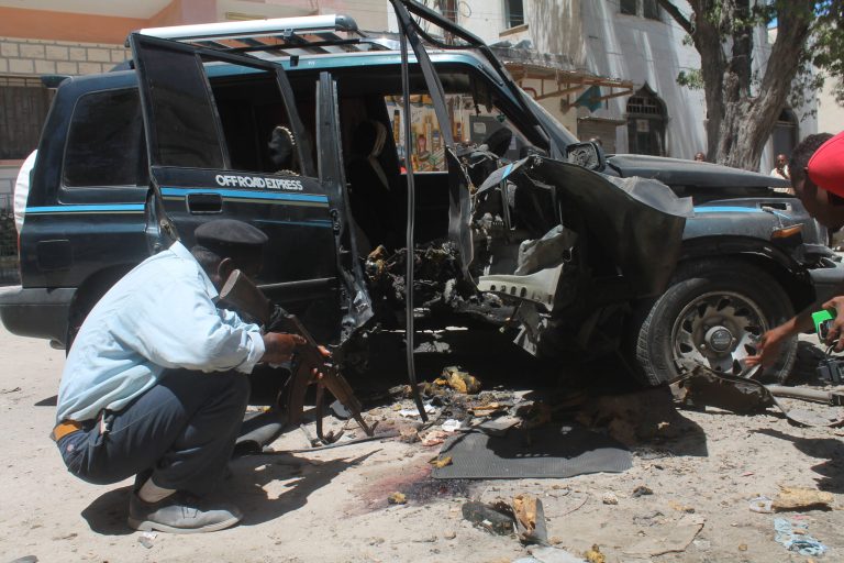 A Somali police officer  looks at the wreckage of the car in Mogadishu, Somalia, Monday, April, 21, 2014. . A Somali police official said a legislator in the country's parliament has been killed in the car bomb explosion in the Somali capital on Monday. Capt. Mohamed Yusuf  said Monday that Isaq Mohamed Rino was killed after a bomb planted under his car exploded in Mogadishu's Hamarweyne neighborhood. The blast also wounded another lawmaker, Mohamed Ali, who was traveling with Rino in the car. (AP Photo/Farah Abdi Warsameh)