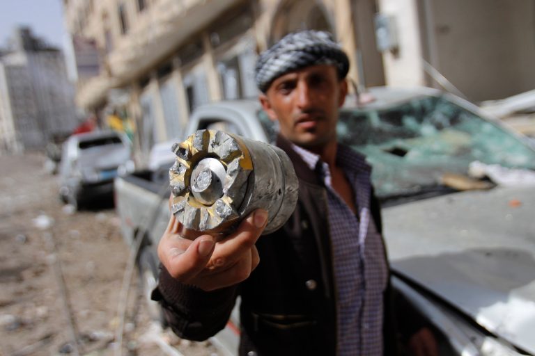 A man holds a projectile fragment after a Saudi-led airstrike against Iran-allied Shiite rebels, known as Houthis, hit a site of a weapons cache and caused massive explosions in Yemen's capital, Monday, April 20, 2015. (AP Photo/Hani Mohammed)